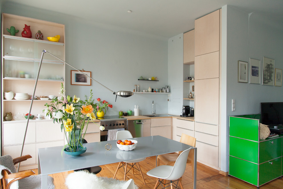 Medium sized scandi l-shaped kitchen/diner in Berlin with flat-panel cabinets, beige cabinets, wood worktops, blue splashback, no island, a built-in sink, stainless steel appliances, light hardwood flooring and brown floors.