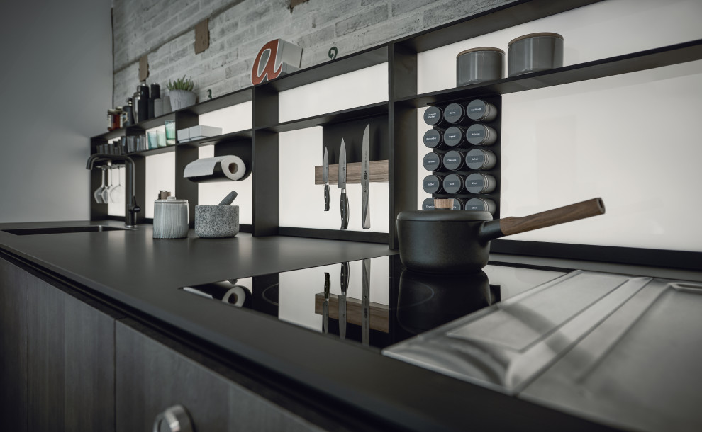 Ejemplo de cocinas en L urbana abierta sin isla con armarios con paneles lisos, puertas de armario de madera en tonos medios y electrodomésticos negros