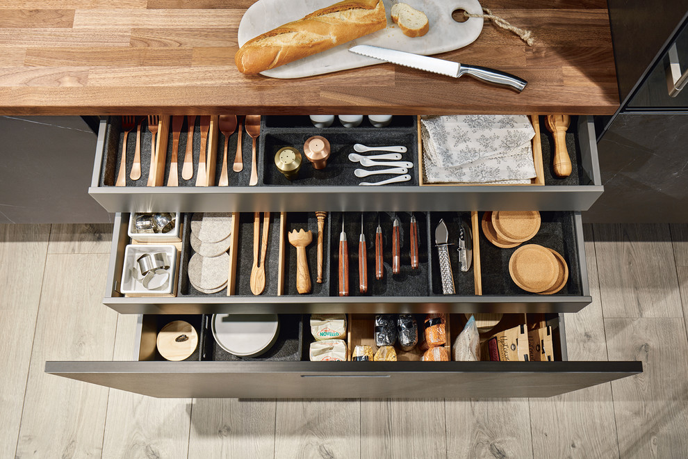 Offene Moderne Küche mit Arbeitsplatte aus Holz, schwarzen Schränken und brauner Arbeitsplatte in Nürnberg