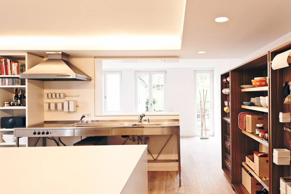 Mid-sized danish medium tone wood floor open concept kitchen photo in Stuttgart with open cabinets, dark wood cabinets, an island, an integrated sink and stainless steel appliances