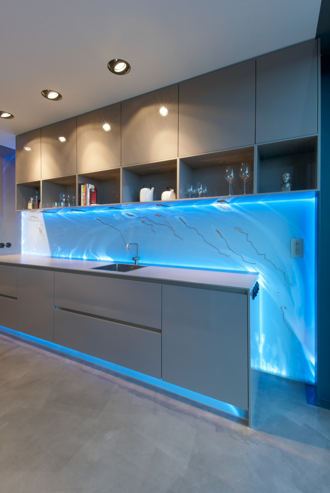 Einzeilige, Große Moderne Wohnküche mit flächenbündigen Schrankfronten, beigen Schränken, Küchenrückwand in Blau, Glasrückwand, schwarzen Elektrogeräten und Kücheninsel in Leipzig