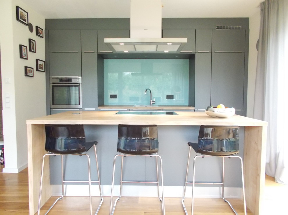 Offene, Zweizeilige Moderne Küche mit grauen Schränken und Kücheninsel in Hamburg