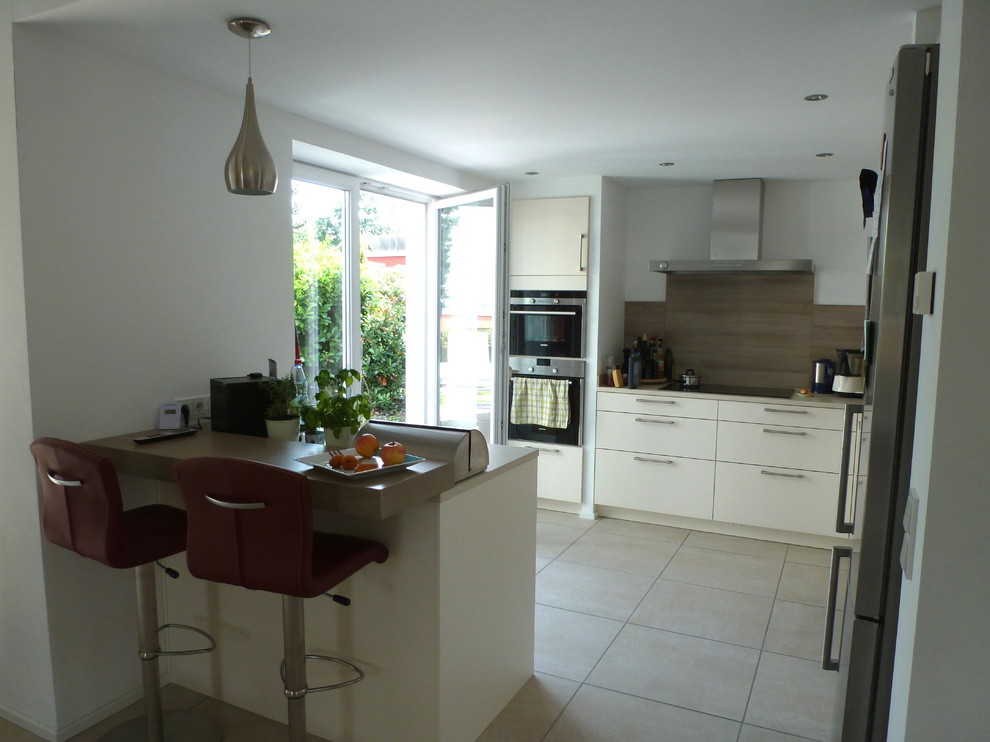 Exempel på ett litet modernt kök, med släta luckor, vita skåp, rostfria vitvaror, en köksö, träbänkskiva och stänkskydd i trä