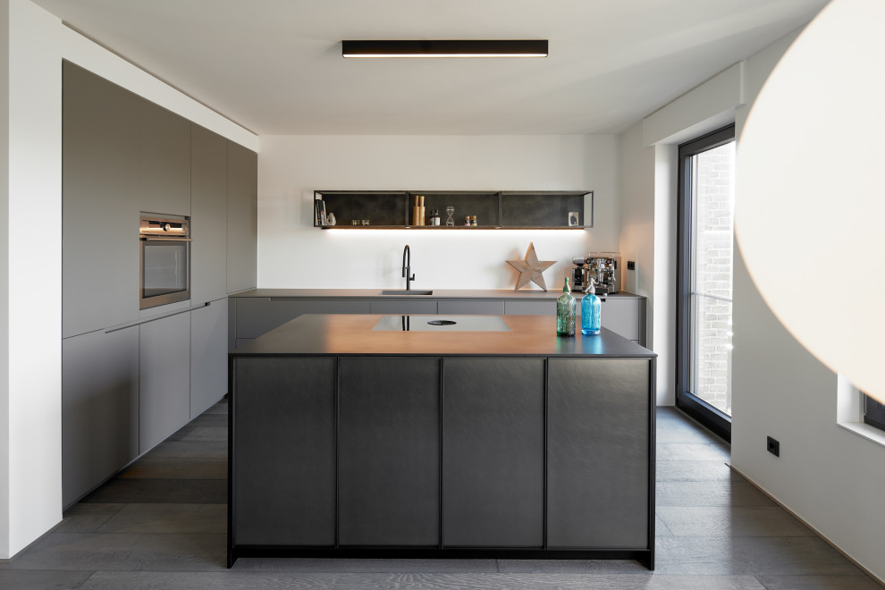 Idéer för att renovera ett mellanstort funkis grå grått kök med öppen planlösning, med en integrerad diskho, släta luckor, grå skåp, vitt stänkskydd, mörkt trägolv, en köksö och brunt golv