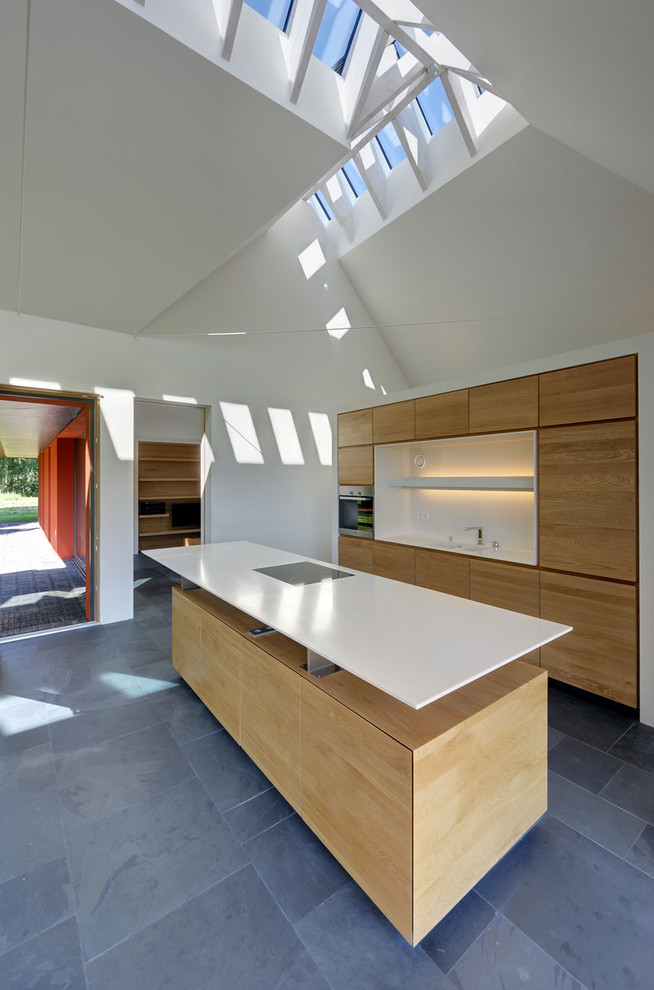 Zweizeilige, Mittelgroße Moderne Küche mit flächenbündigen Schrankfronten, hellen Holzschränken, Küchenrückwand in Weiß, Schieferboden und Kücheninsel in Berlin