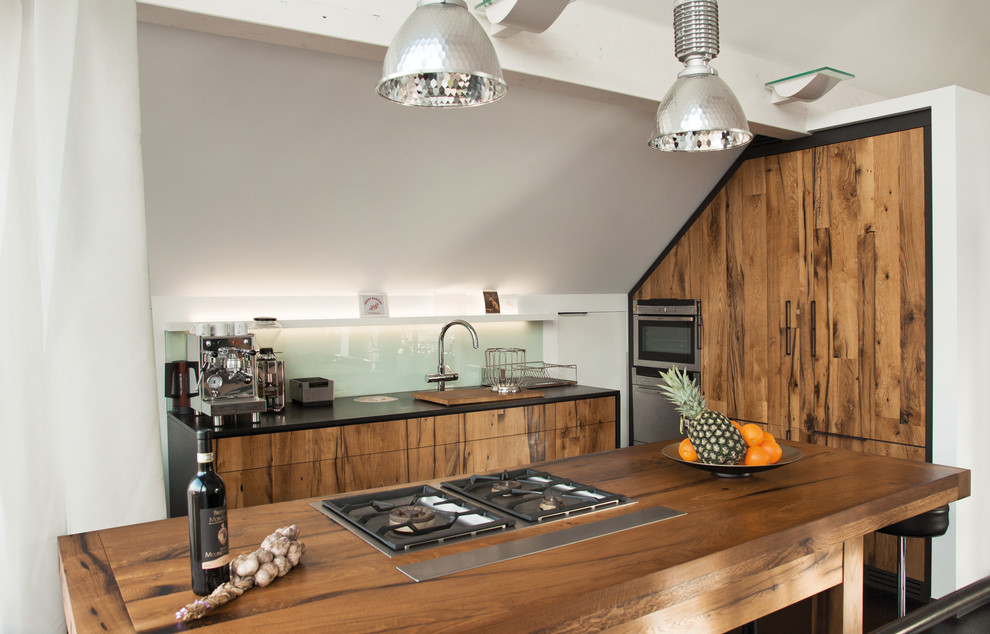 Immagine di una cucina boho chic con lavello da incasso, ante lisce, top in legno, paraspruzzi con lastra di vetro, elettrodomestici in acciaio inossidabile e ante in legno scuro