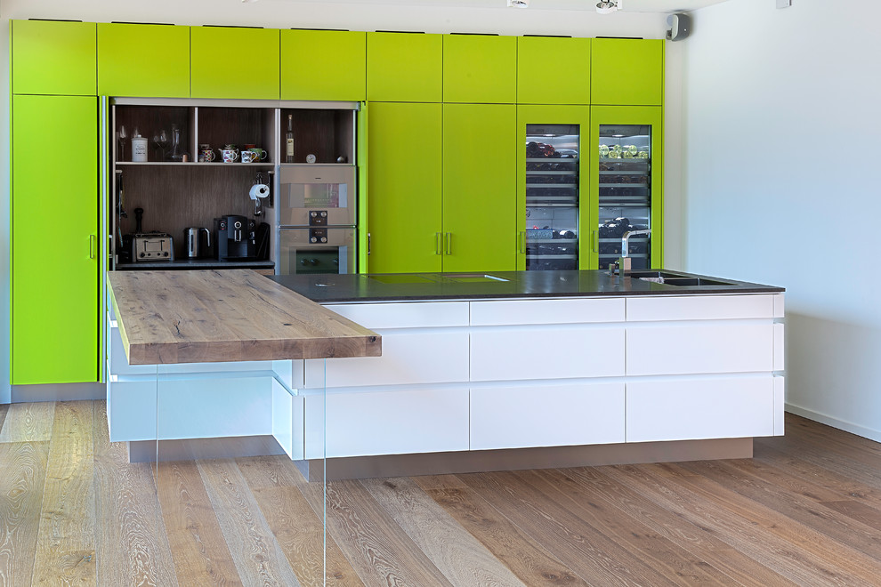 Idee per una cucina design con lavello a doppia vasca, ante verdi, paraspruzzi marrone e elettrodomestici in acciaio inossidabile