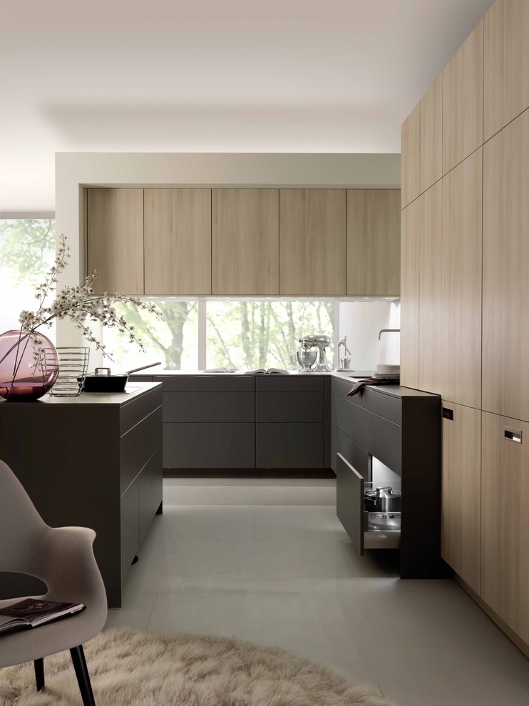 Example of a mid-sized minimalist l-shaped open concept kitchen design in Stuttgart with flat-panel cabinets, light wood cabinets and an island