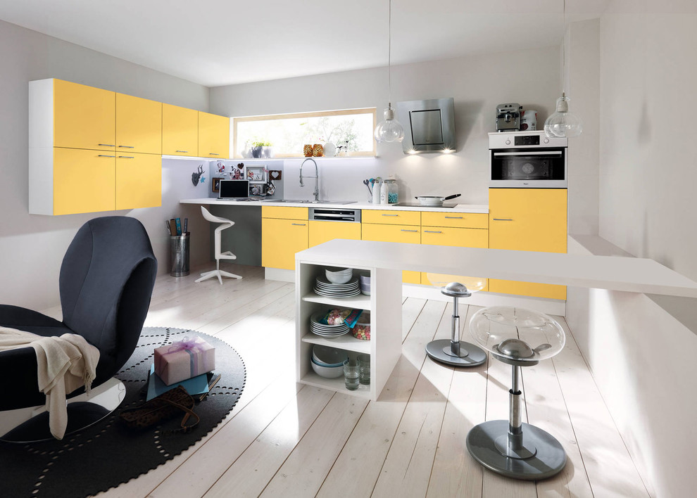 На фото: маленькая прямая кухня-гостиная в современном стиле с желтыми фасадами и белым фартуком для на участке и в саду