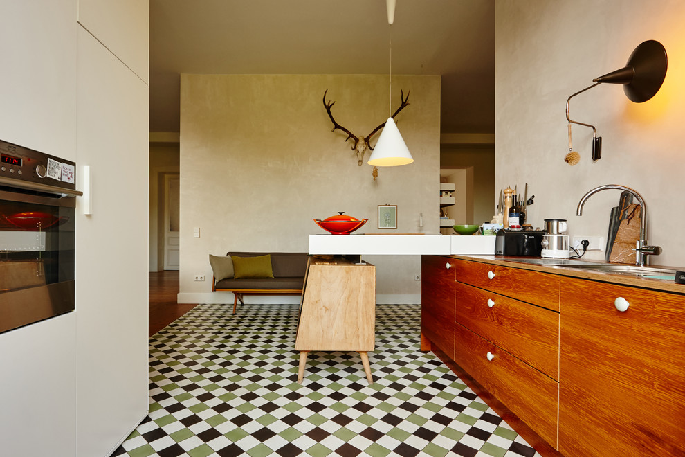 Ispirazione per una grande cucina minimalista con ante di vetro, ante marroni e top in legno