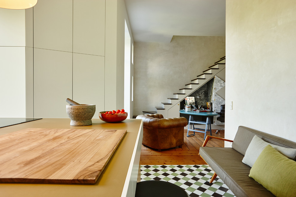 Пример оригинального дизайна: большая угловая кухня-гостиная в современном стиле с стеклянными фасадами, коричневыми фасадами и деревянной столешницей