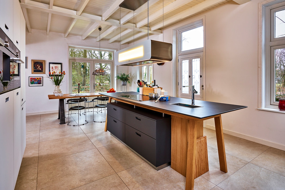 Idee per un'ampia cucina contemporanea con ante lisce, elettrodomestici neri, pavimento con piastrelle in ceramica e pavimento beige