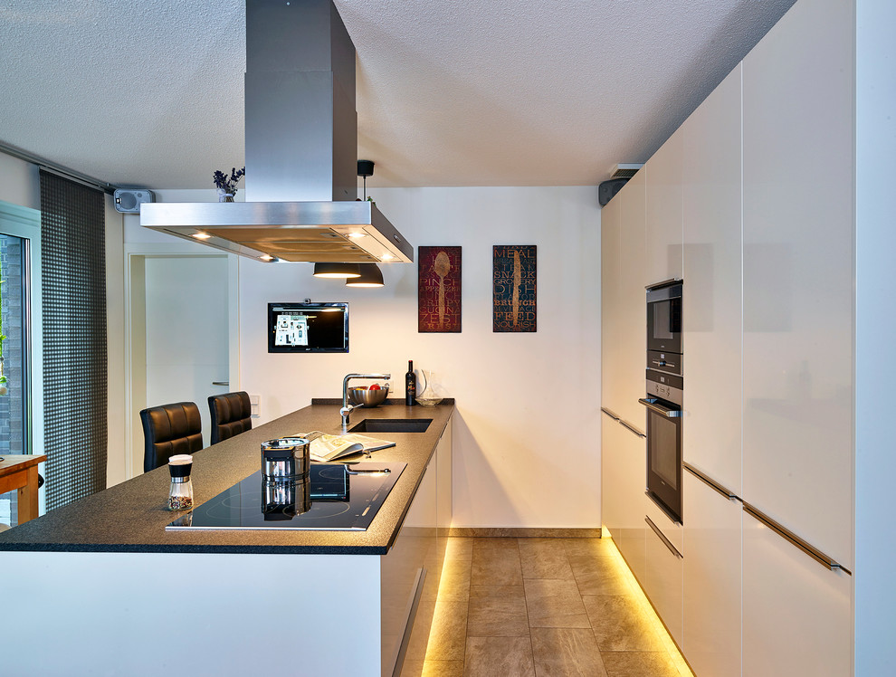Exempel på ett avskilt, mellanstort modernt linjärt kök, med en nedsänkt diskho, släta luckor, vita skåp, granitbänkskiva, svarta vitvaror och en köksö