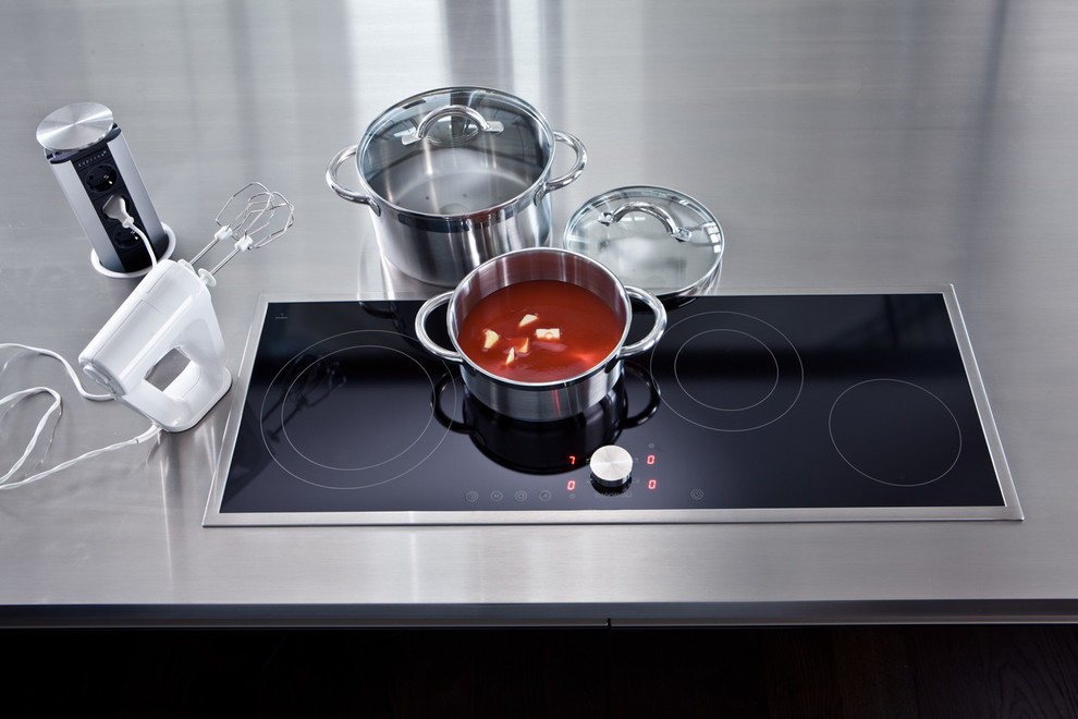 Esempio di un'ampia cucina design con lavello a vasca singola, ante nere, top in acciaio inossidabile e elettrodomestici in acciaio inossidabile