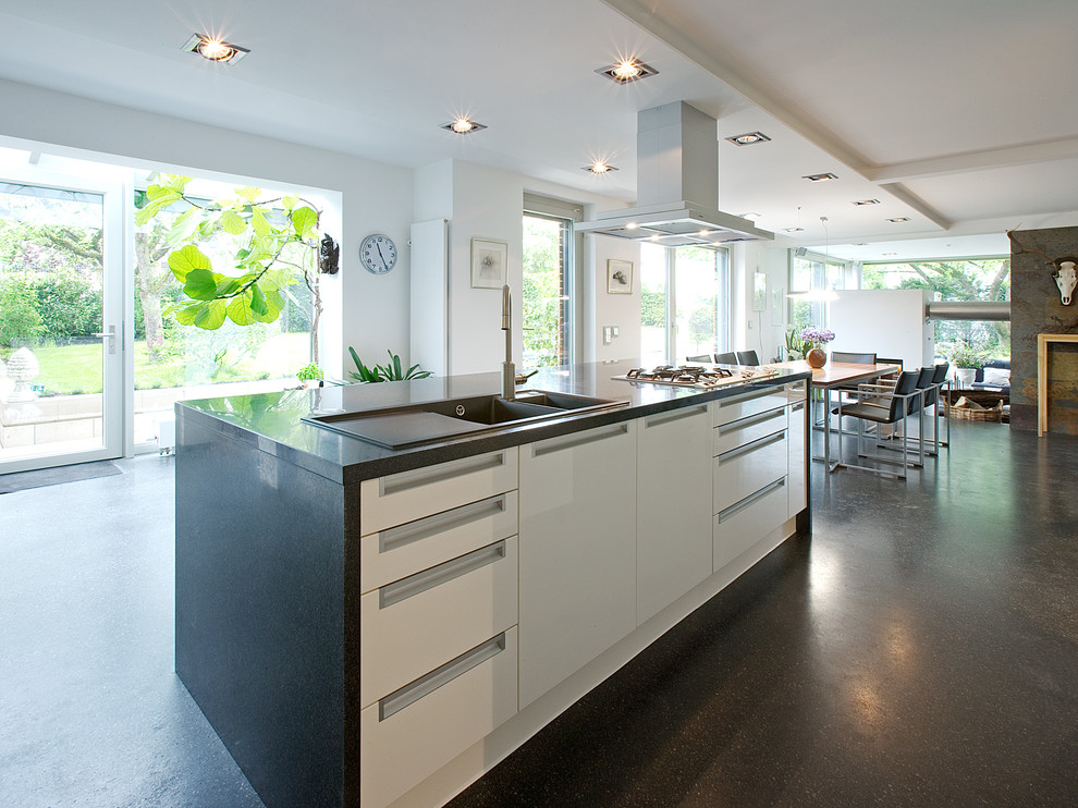 Стильный дизайн: огромная кухня-гостиная в современном стиле с плоскими фасадами, белыми фасадами и островом - последний тренд