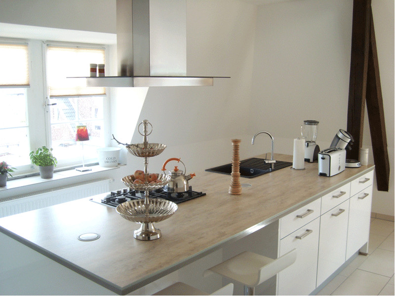 Foto di una cucina minimal di medie dimensioni con lavello da incasso, ante lisce, ante bianche, paraspruzzi bianco e elettrodomestici in acciaio inossidabile