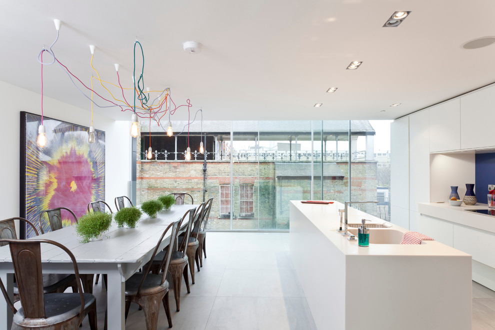 Trendy galley eat-in kitchen photo in London with an integrated sink, flat-panel cabinets, white cabinets and blue backsplash
