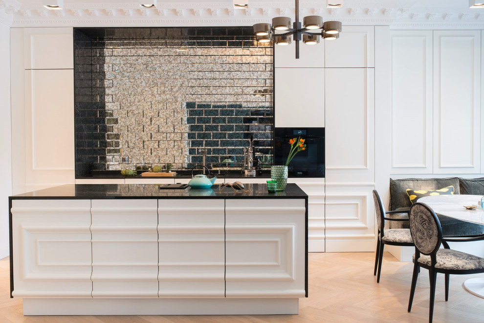 Eat-in kitchen - large contemporary galley porcelain tile and beige floor eat-in kitchen idea in Hamburg with an undermount sink, white cabinets, black backsplash, glass tile backsplash, paneled appliances, an island and black countertops