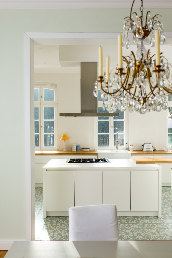 Foto di una cucina design di medie dimensioni con lavello da incasso, ante lisce, ante bianche, top in legno, elettrodomestici da incasso, pavimento in gres porcellanato e top bianco