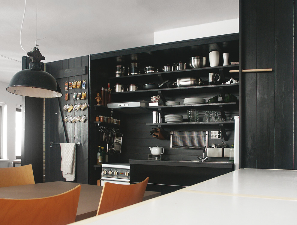 Photo of a small contemporary single-wall kitchen in Leipzig with black cabinets, grey splashback and wood splashback.