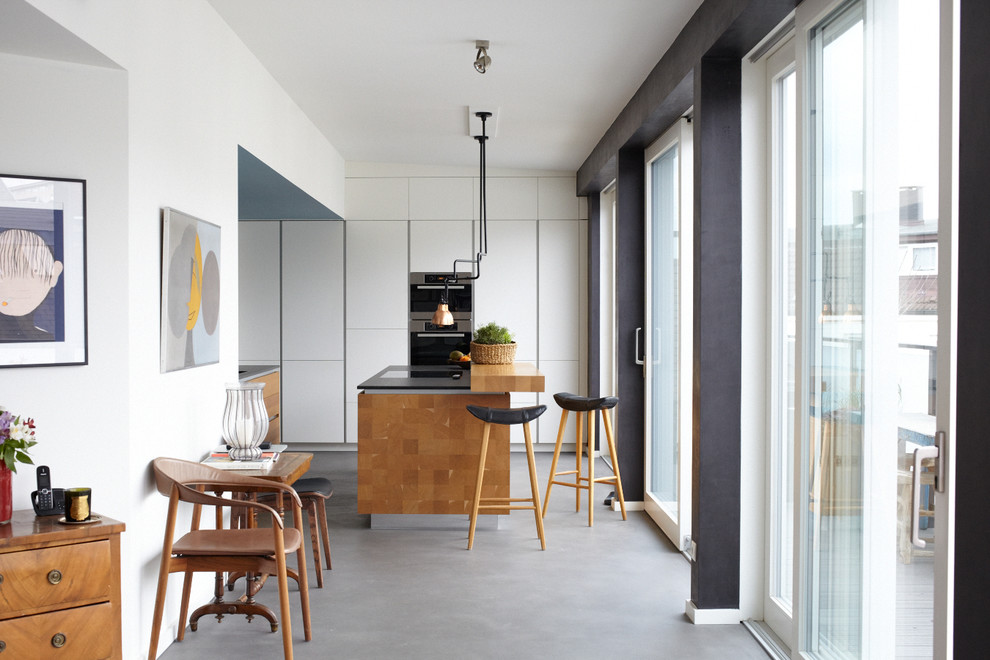 Foto di una cucina contemporanea di medie dimensioni con ante lisce, ante bianche, elettrodomestici in acciaio inossidabile, pavimento in vinile, 2 o più isole e pavimento grigio