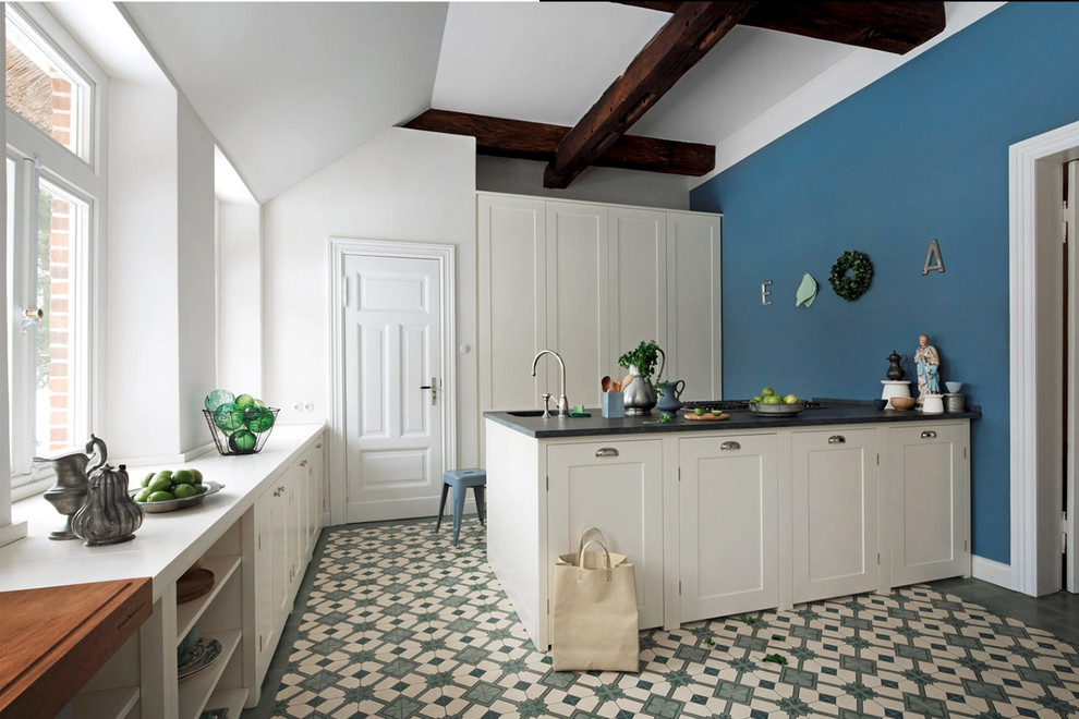 Diseño de cocina tradicional grande cerrada con armarios con rebordes decorativos, puertas de armario blancas, salpicadero azul, suelo de baldosas de porcelana y península