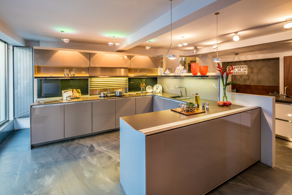 Offene, Große Moderne Küche in U-Form mit Waschbecken, beigen Schränken, Granit-Arbeitsplatte, bunter Rückwand, Glasrückwand und Betonboden in Frankfurt am Main