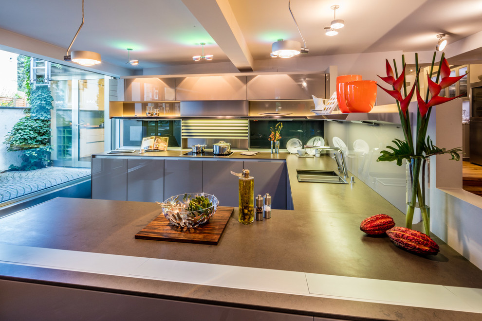 Bild på ett stort funkis kök, med en enkel diskho, beige skåp, granitbänkskiva, flerfärgad stänkskydd, glaspanel som stänkskydd och betonggolv