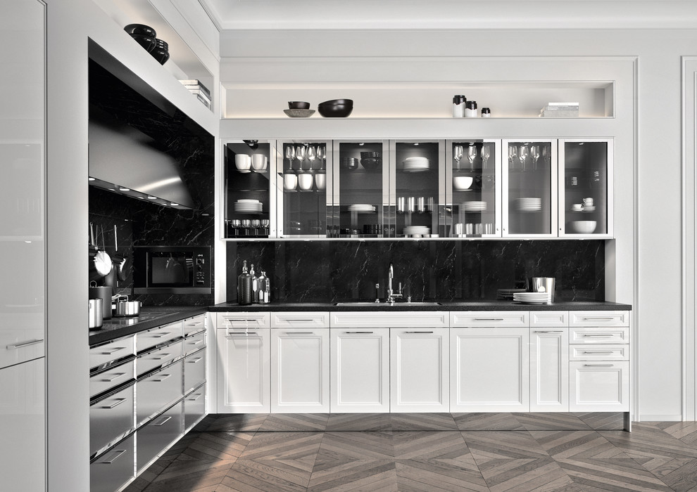 Große, Offene Klassische Küche ohne Insel in L-Form mit profilierten Schrankfronten, weißen Schränken, Granit-Arbeitsplatte, Küchenrückwand in Schwarz, Rückwand aus Stein, Küchengeräten aus Edelstahl und braunem Holzboden in München
