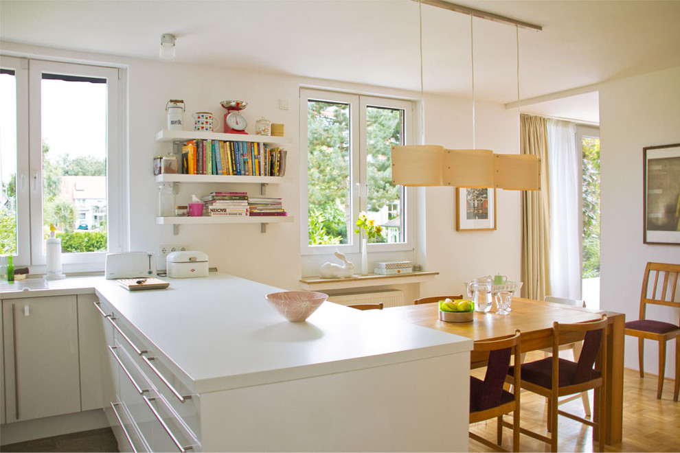 Foto de cocina comedor nórdica de tamaño medio con armarios con paneles lisos, puertas de armario blancas, suelo de madera en tonos medios y península