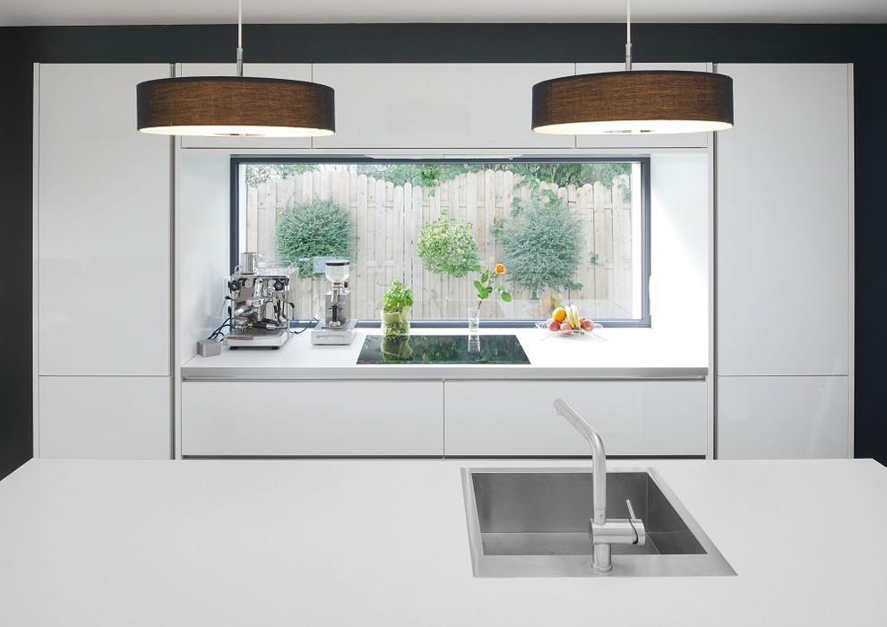 Ispirazione per una grande cucina moderna con lavello a vasca singola, ante lisce, ante bianche e pavimento in legno massello medio