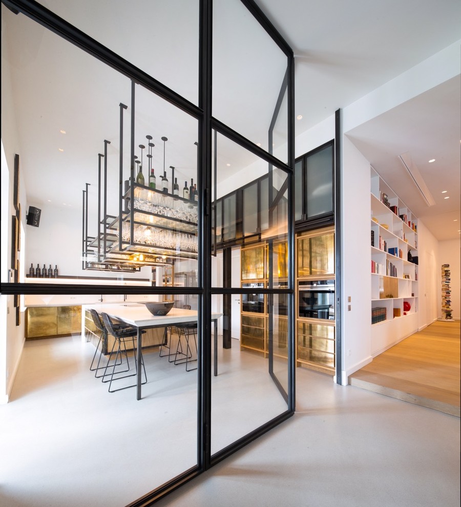 This is an example of a large contemporary enclosed kitchen in Frankfurt with a submerged sink, beaded cabinets, concrete worktops, black splashback, black appliances, concrete flooring, an island, beige floors and beige worktops.