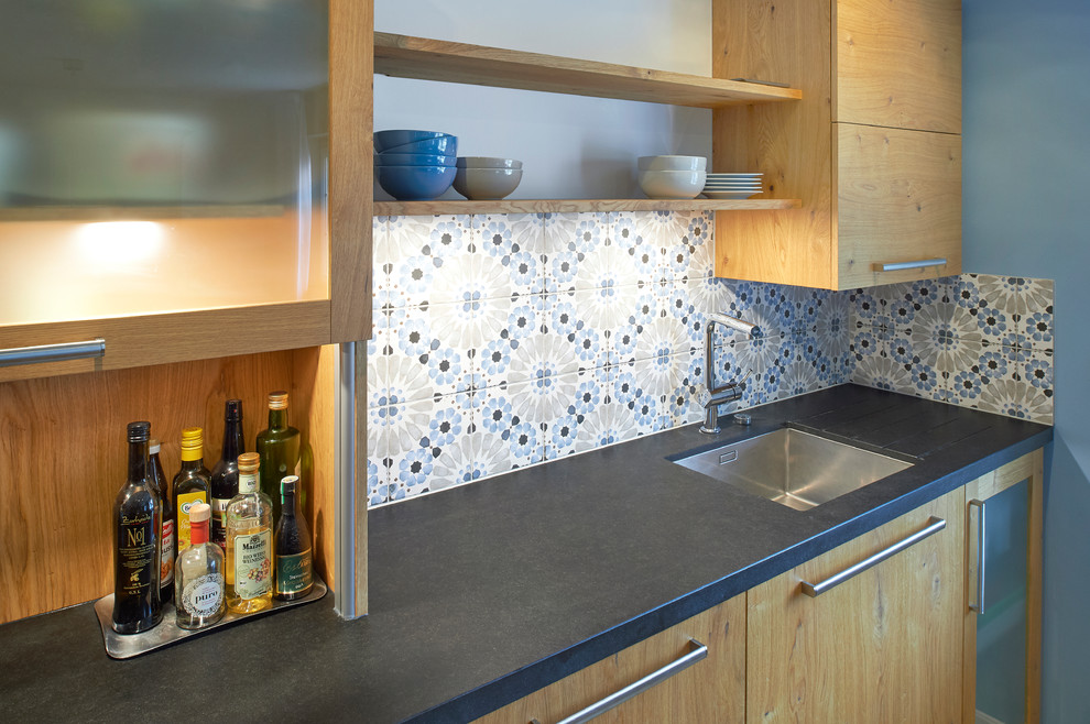 Idéer för ett mycket stort lantligt svart kök med öppen planlösning, med en undermonterad diskho, släta luckor, skåp i mellenmörkt trä, blått stänkskydd, betonggolv, en halv köksö, grått golv, marmorbänkskiva, stänkskydd i stenkakel och rostfria vitvaror
