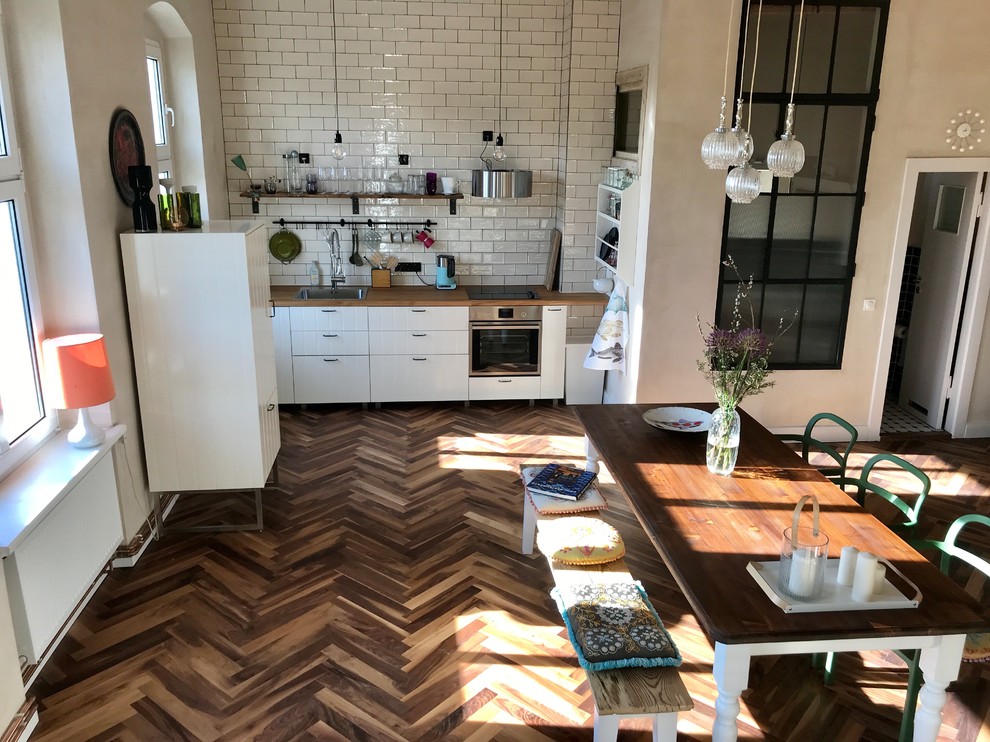 Design ideas for a large country single-wall open plan kitchen in Berlin with beaded cabinets, white cabinets, wood worktops, white splashback, metro tiled splashback, painted wood flooring, no island and brown worktops.