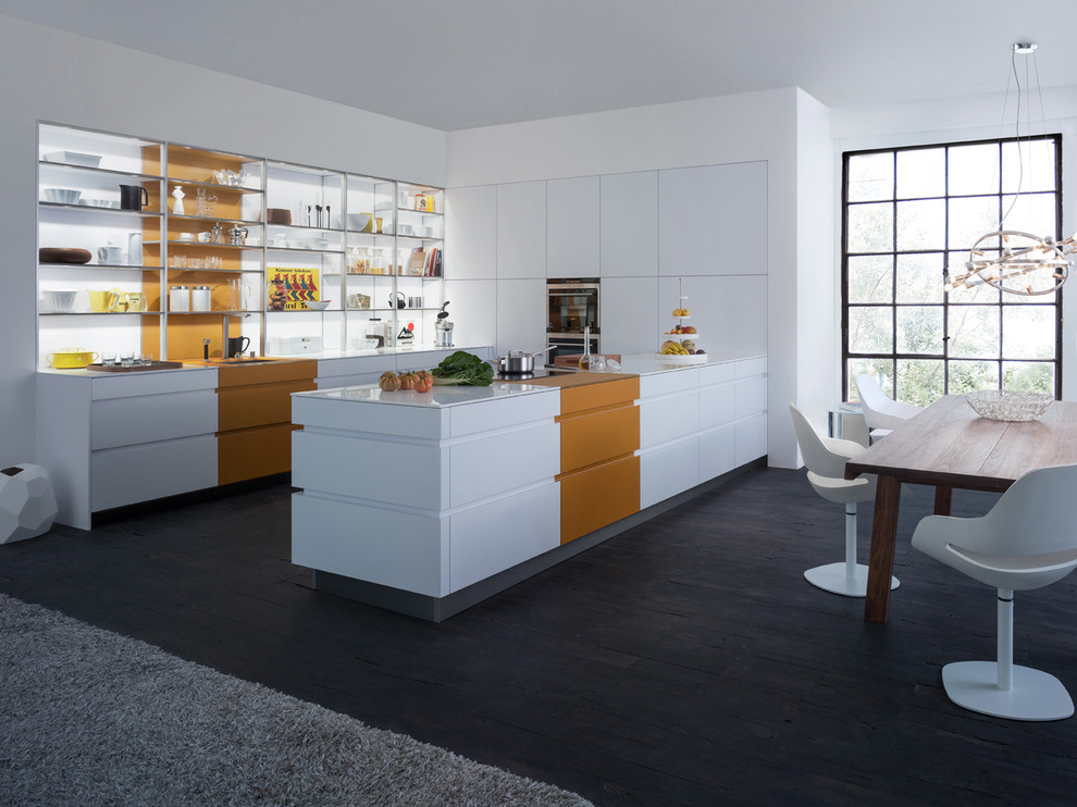 Inredning av ett modernt mellanstort kök, med en undermonterad diskho, öppna hyllor, vita skåp, integrerade vitvaror, mörkt trägolv och en halv köksö
