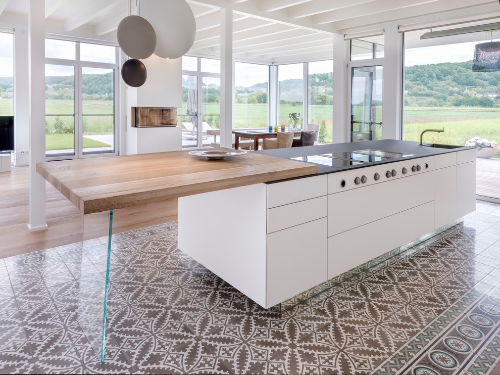 Ejemplo de cocina comedor contemporánea con armarios con paneles lisos, puertas de armario blancas, una isla, fregadero de un seno y suelo multicolor