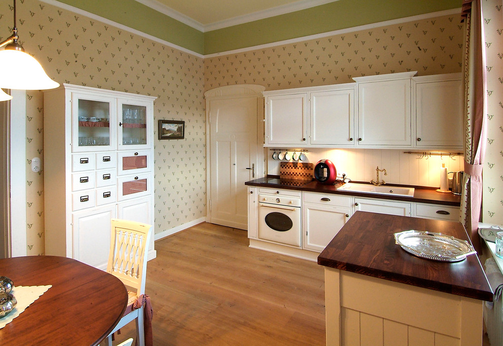 Cette photo montre une cuisine linéaire chic fermée et de taille moyenne avec papier peint.