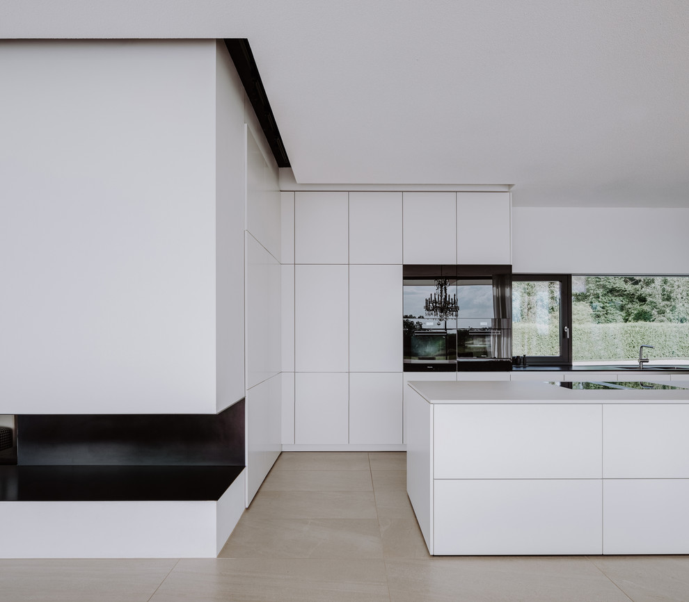 Immagine di una grande cucina moderna con lavello a doppia vasca, ante lisce, ante bianche, paraspruzzi bianco, elettrodomestici in acciaio inossidabile, pavimento in pietra calcarea e pavimento grigio