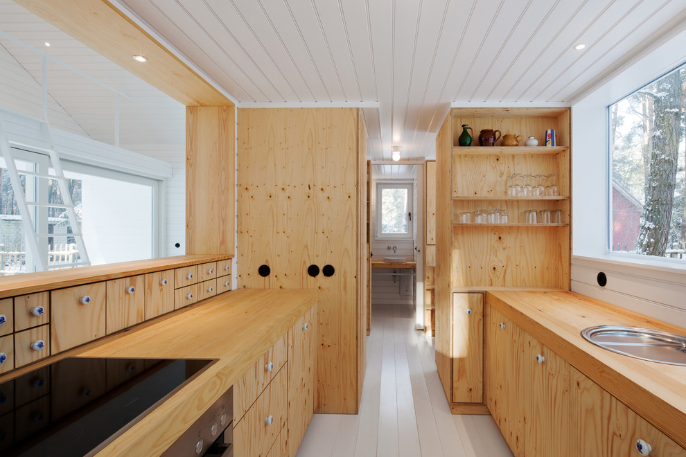 Свежая идея для дизайна: маленькая, узкая параллельная кухня-гостиная в скандинавском стиле с плоскими фасадами, светлыми деревянными фасадами, деревянной столешницей, деревянным полом, накладной мойкой и техникой под мебельный фасад без острова для на участке и в саду - отличное фото интерьера