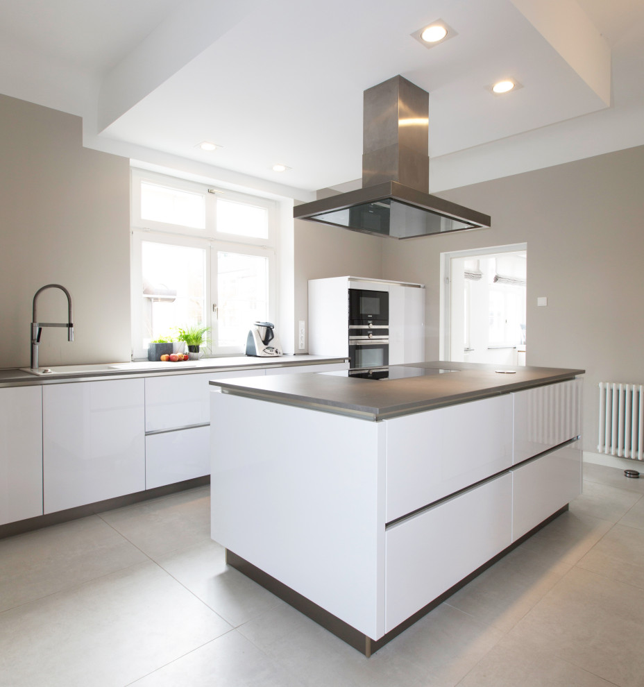 Inspiration for a large contemporary galley kitchen in Other with an integrated sink, flat-panel cabinets, white cabinets, integrated appliances, porcelain flooring, an island, grey floors and grey worktops.