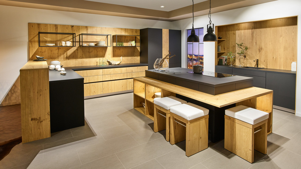 Example of a large urban u-shaped gray floor eat-in kitchen design in Dresden with flat-panel cabinets, light wood cabinets, wood countertops, brown backsplash, wood backsplash and an island