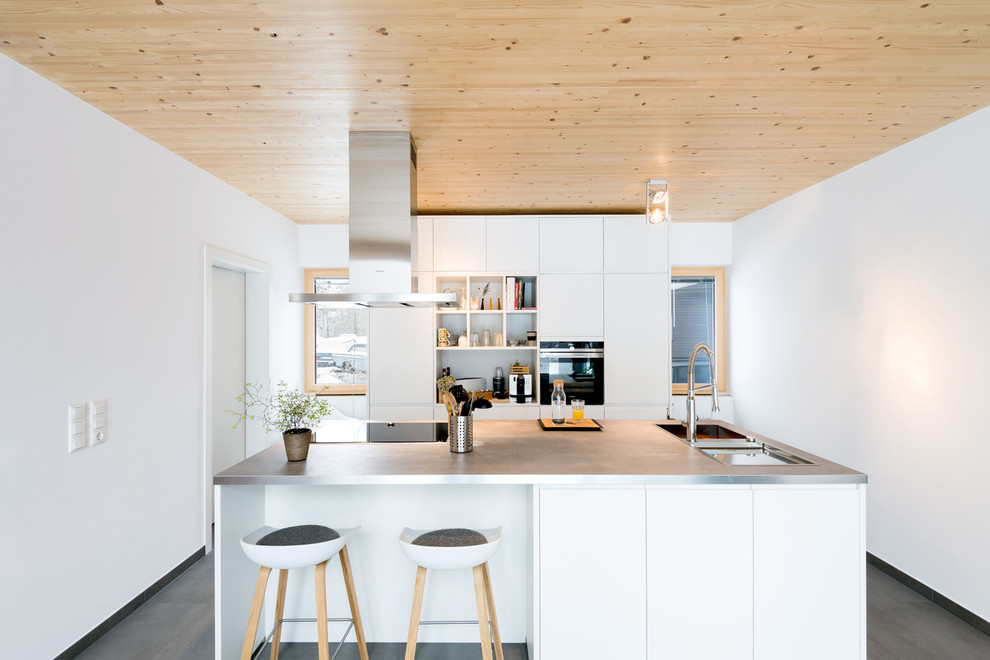 Offene Moderne Küche mit weißen Schränken, Laminat-Arbeitsplatte, Küchenrückwand in Weiß und Kücheninsel in Nürnberg