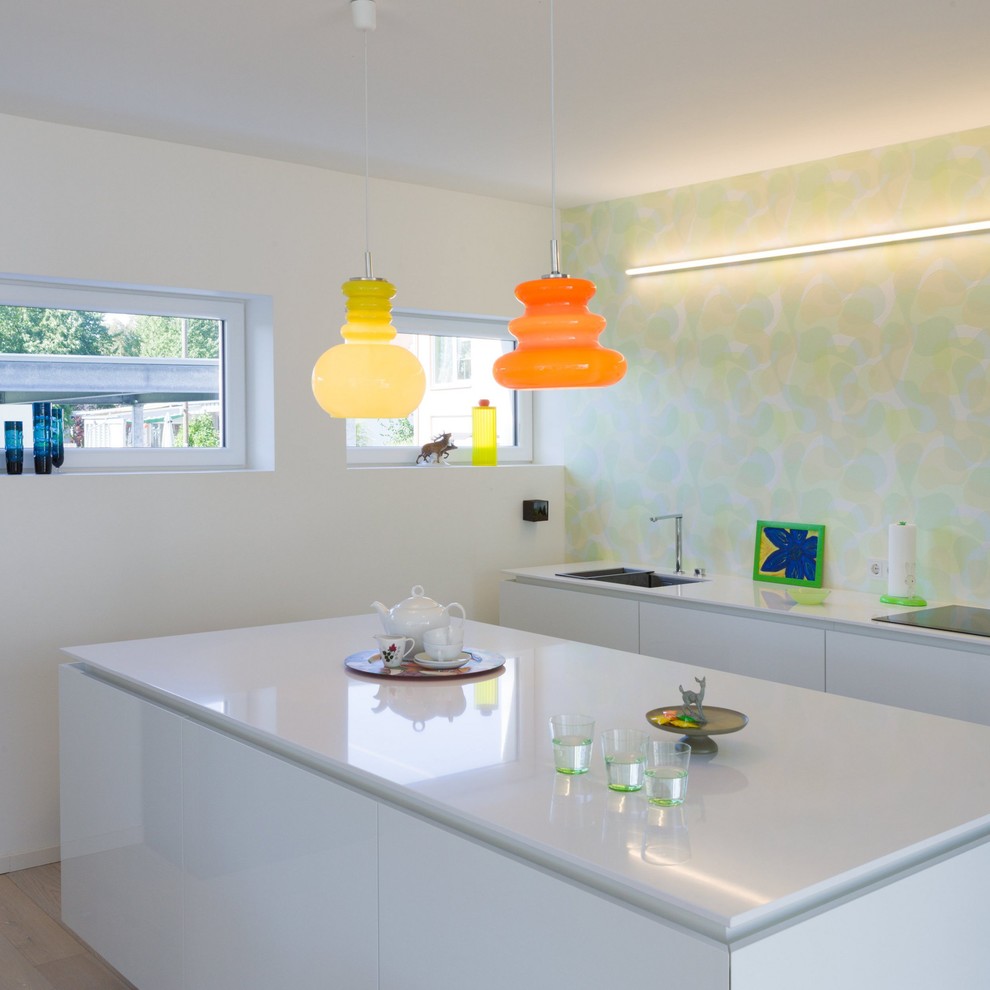 Immagine di un cucina con isola centrale design chiuso e di medie dimensioni con lavello a doppia vasca, ante lisce, ante bianche e parquet chiaro