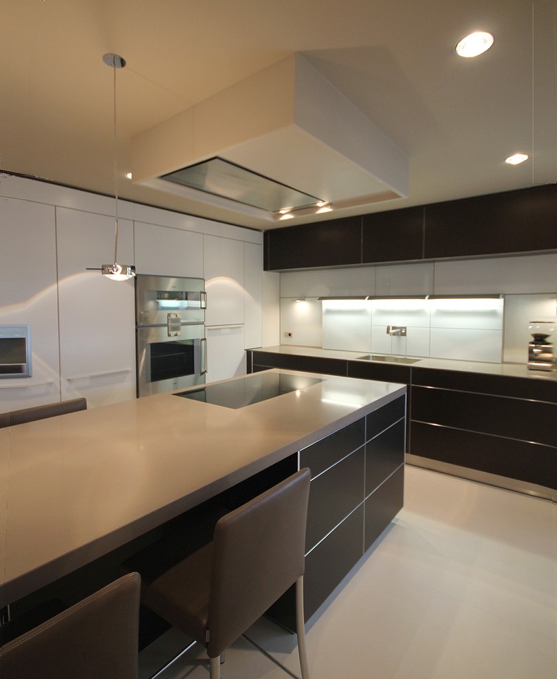 Esempio di una piccola cucina minimal con lavello da incasso, ante lisce, ante nere, paraspruzzi blu, paraspruzzi con lastra di vetro, elettrodomestici in acciaio inossidabile e pavimento beige