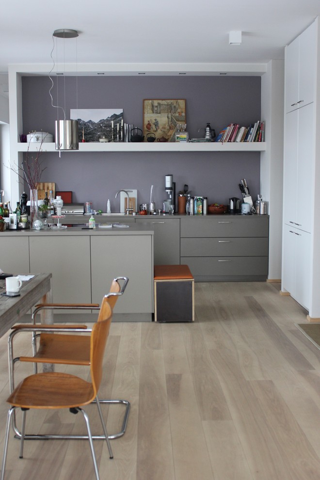 Idee per una cucina minimal di medie dimensioni con ante lisce, ante grigie, pavimento in legno massello medio e lavello da incasso