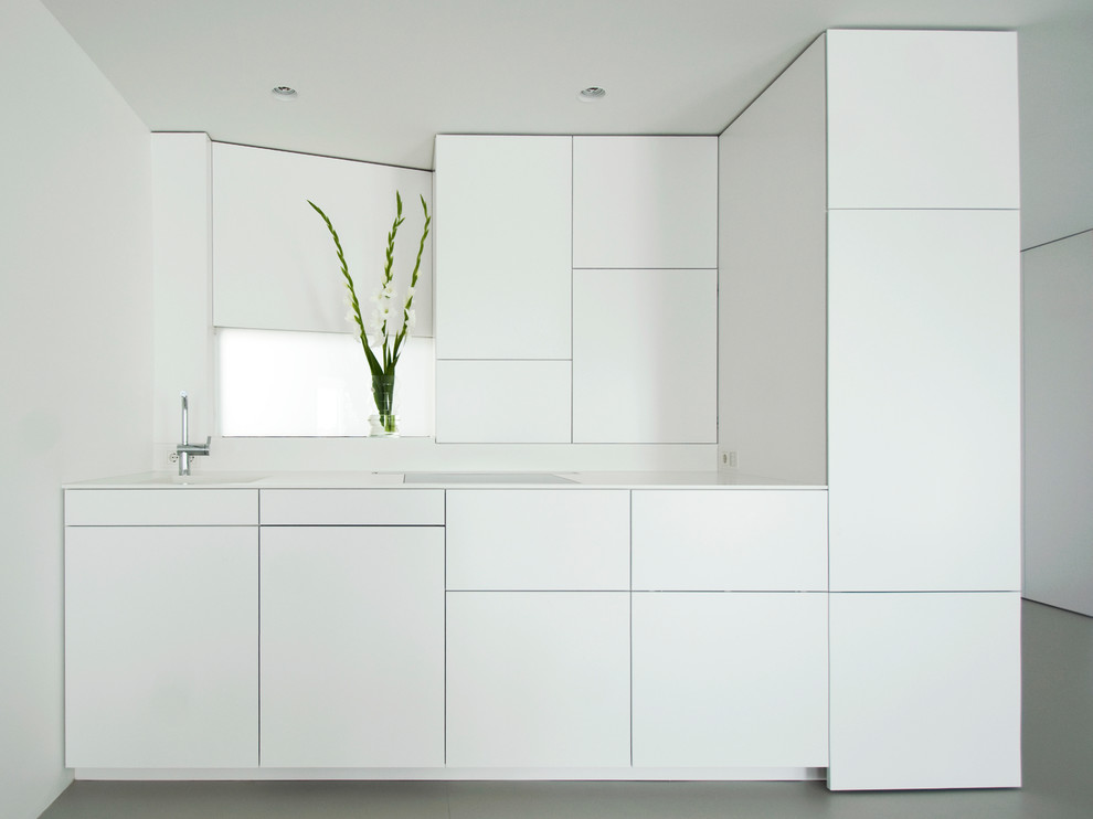 Modelo de cocina lineal minimalista pequeña abierta con fregadero de un seno, armarios con paneles lisos, puertas de armario blancas y suelo de cemento