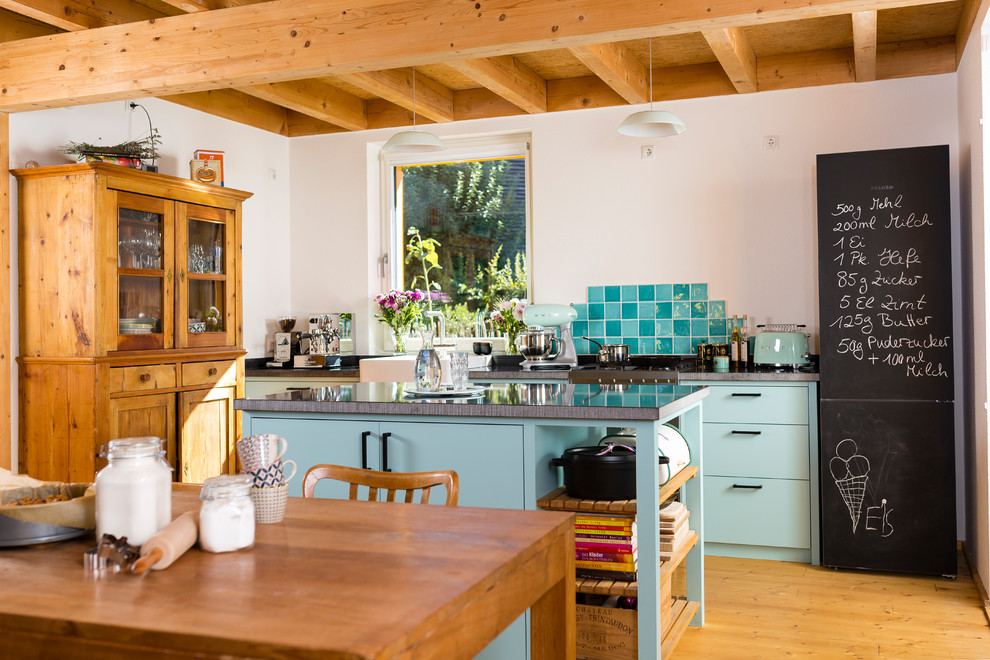 Cette photo montre une cuisine ouverte parallèle romantique avec un évier posé, des portes de placard turquoises, une crédence blanche, une crédence en mosaïque, un sol en bois brun et îlot.