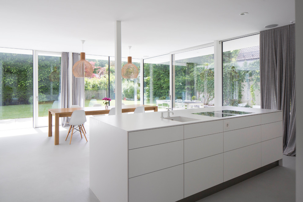 Inspiration for a mid-sized contemporary concrete floor eat-in kitchen remodel in Munich with an integrated sink, flat-panel cabinets, white cabinets and an island