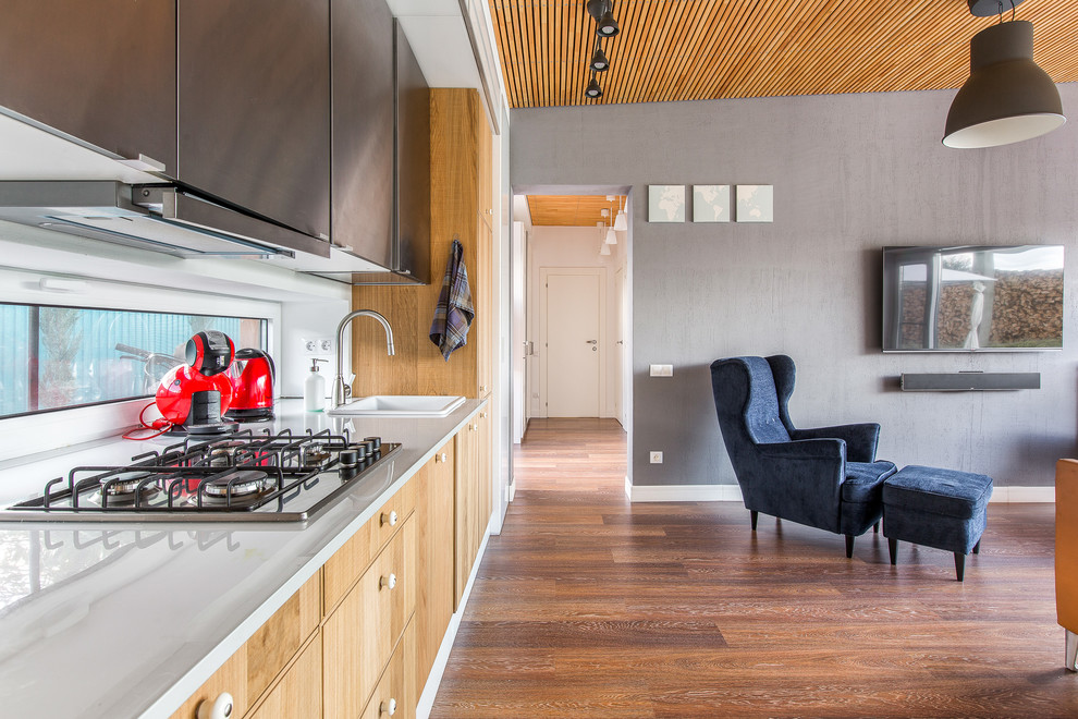 Immagine di una cucina minimal con ante lisce, pavimento in legno massello medio, nessuna isola, ante in legno chiaro e paraspruzzi a finestra