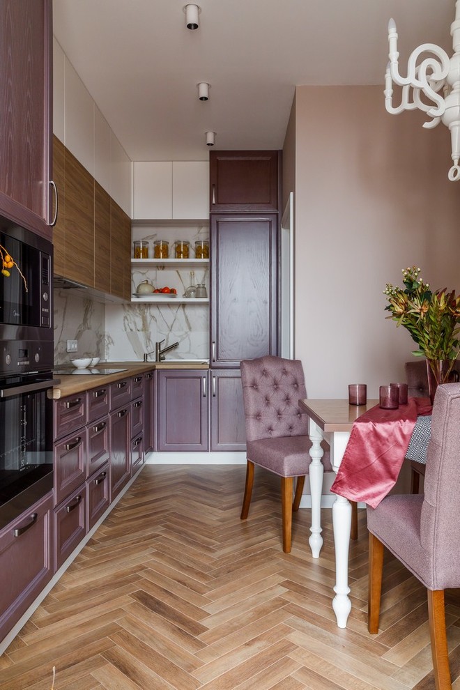 Cette image montre une cuisine américaine design en L avec des portes de placard violettes, une crédence beige, aucun îlot, un sol marron et un plan de travail marron.